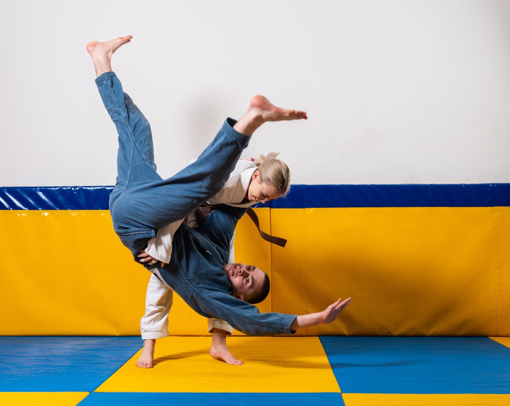 Young girls and boys practice Brazilian jiu jitsu in the gym